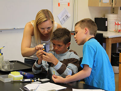 Two boys with an instructor in a science program