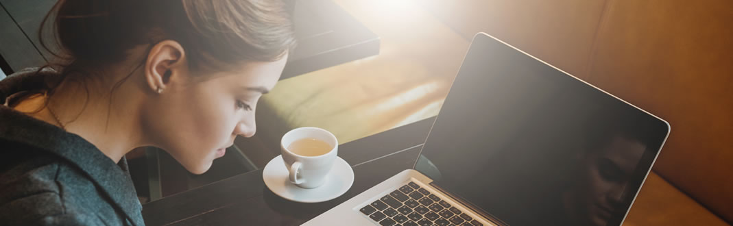 Image of student with a laptop and tea