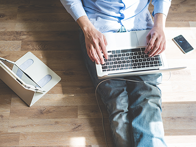 Man with a tablet, a laptop, and a phone