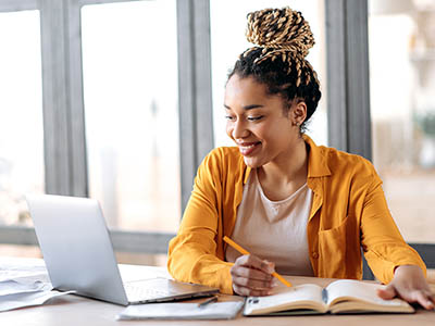 African American woman with a book and a laptop